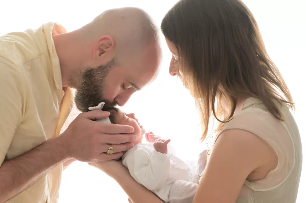 Couple de parents avec leur bébé lors d'une séance chez le photographe